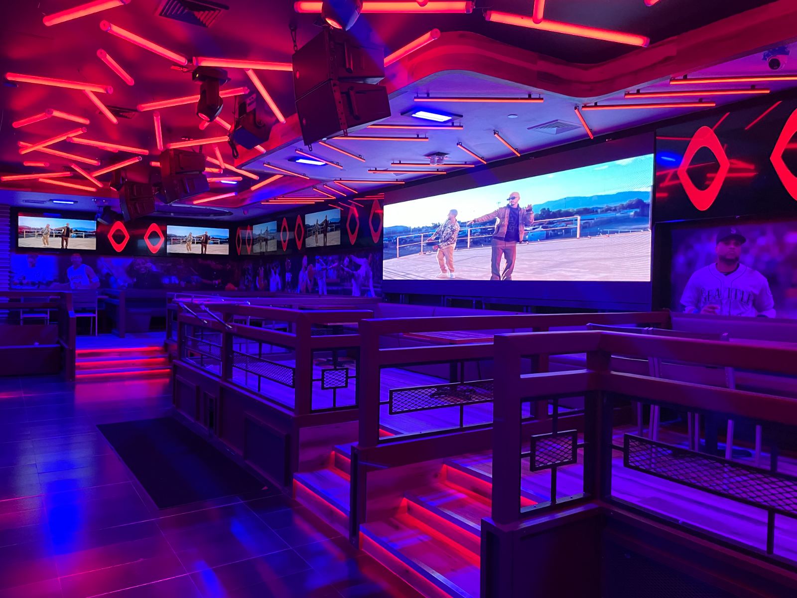 The lounge bar under red and blue architectural LED with screens above