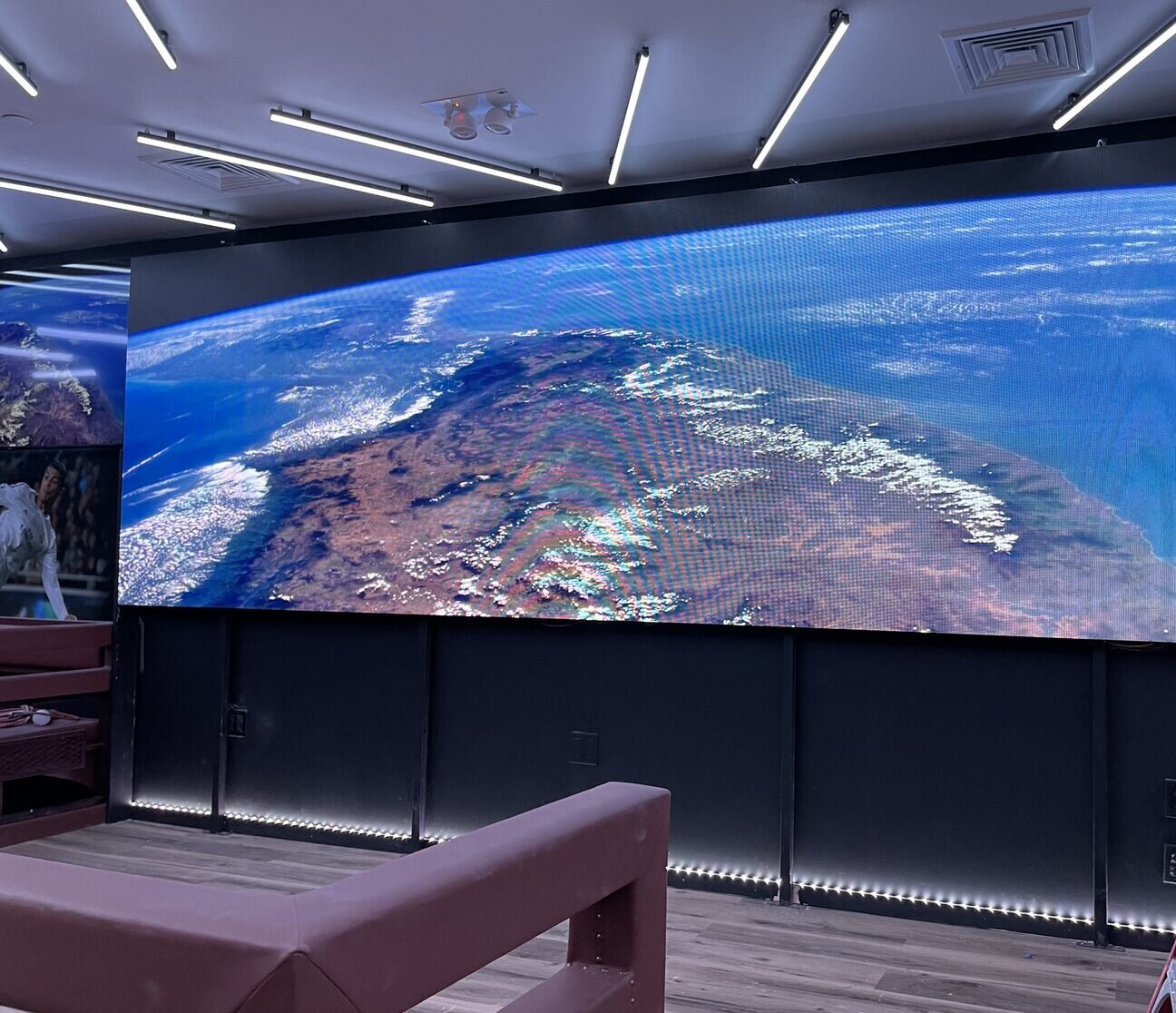 A wall-sized direct-view LED display running in a sports lounge