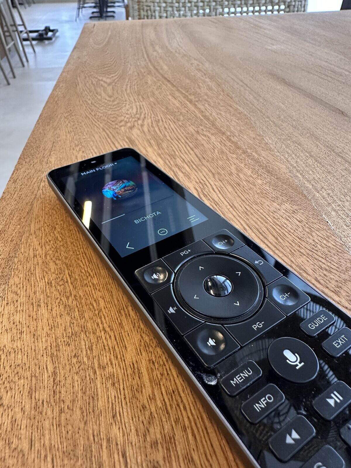 A handheld remote showing the main-floor zone and what's playing