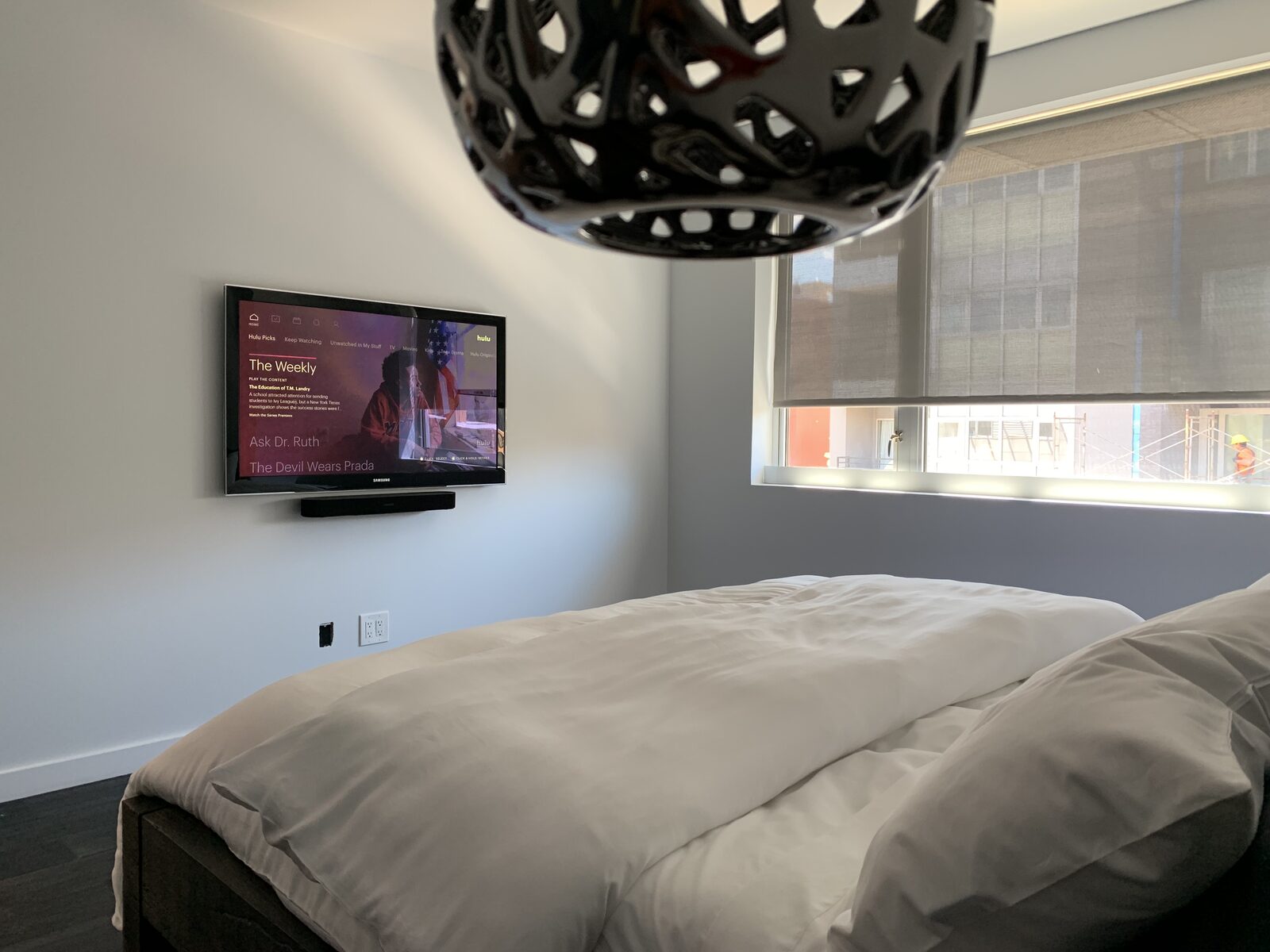 A bedroom display and soundbar under a pendant light