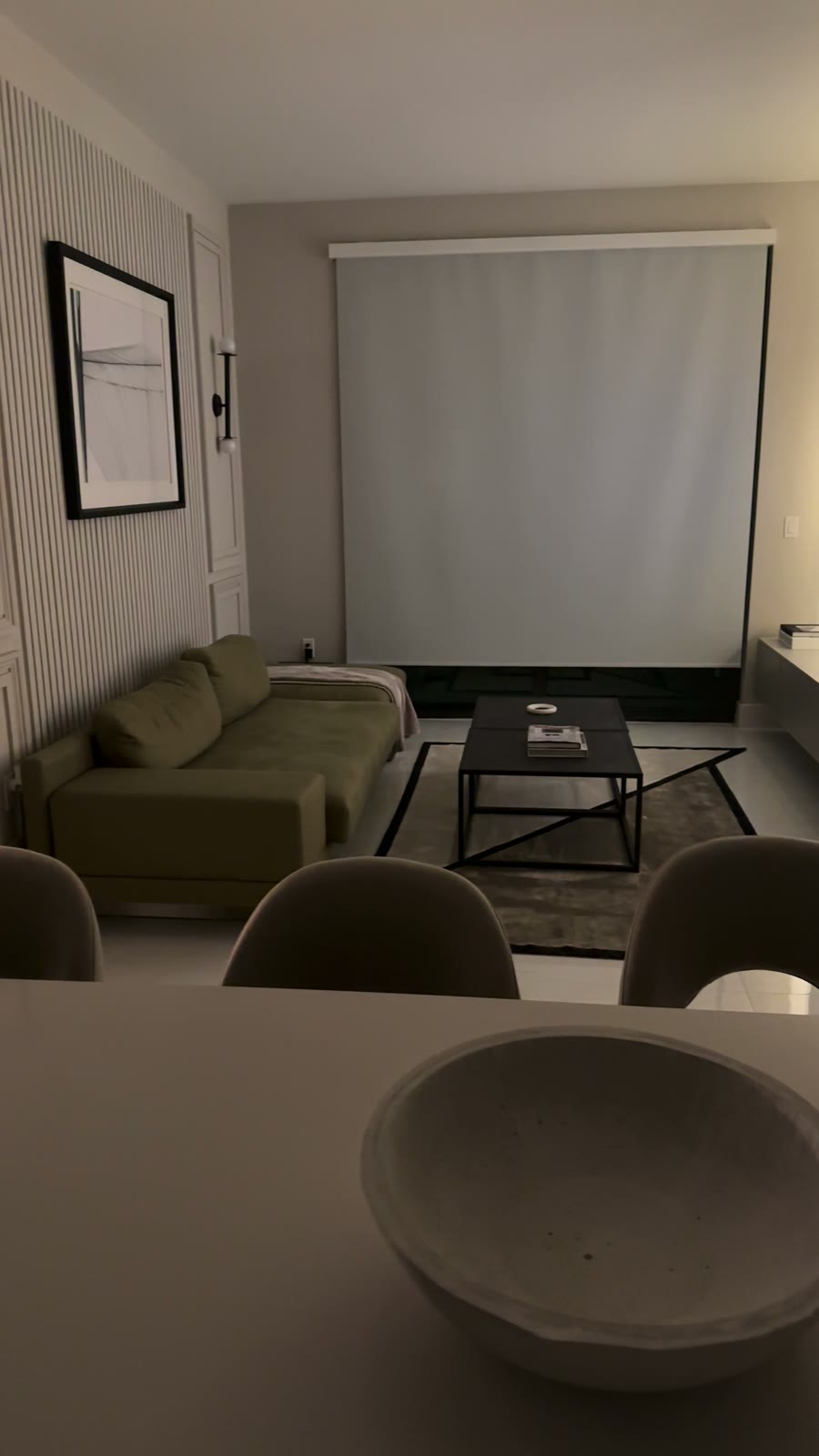 A living room with a motorised shade lowered across the window