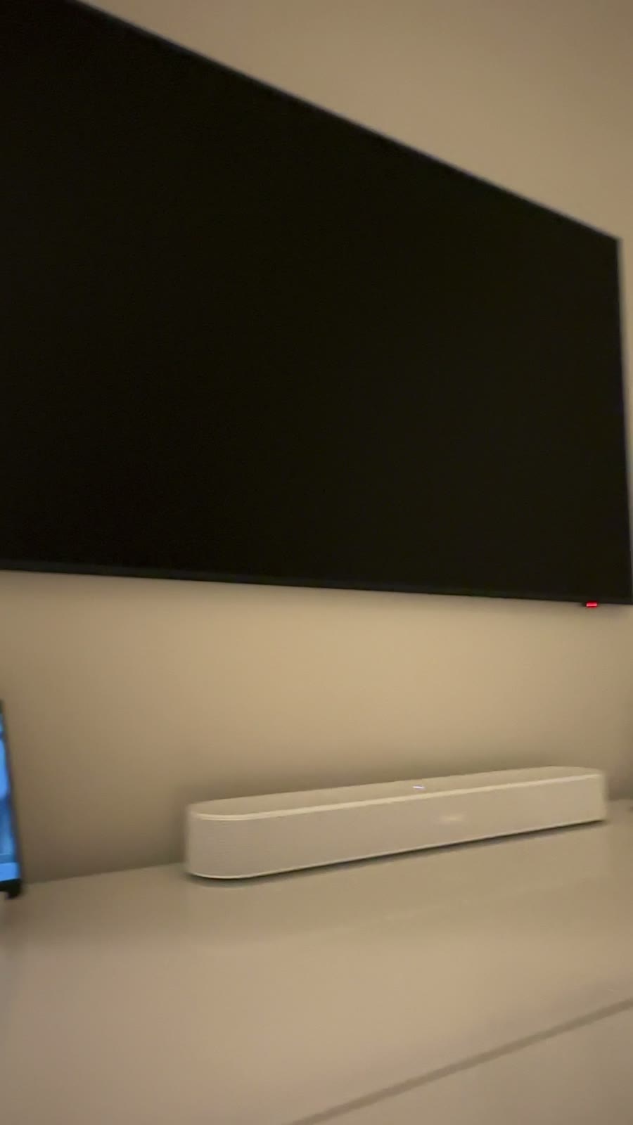 A wall-mounted display and soundbar above concealed lighting