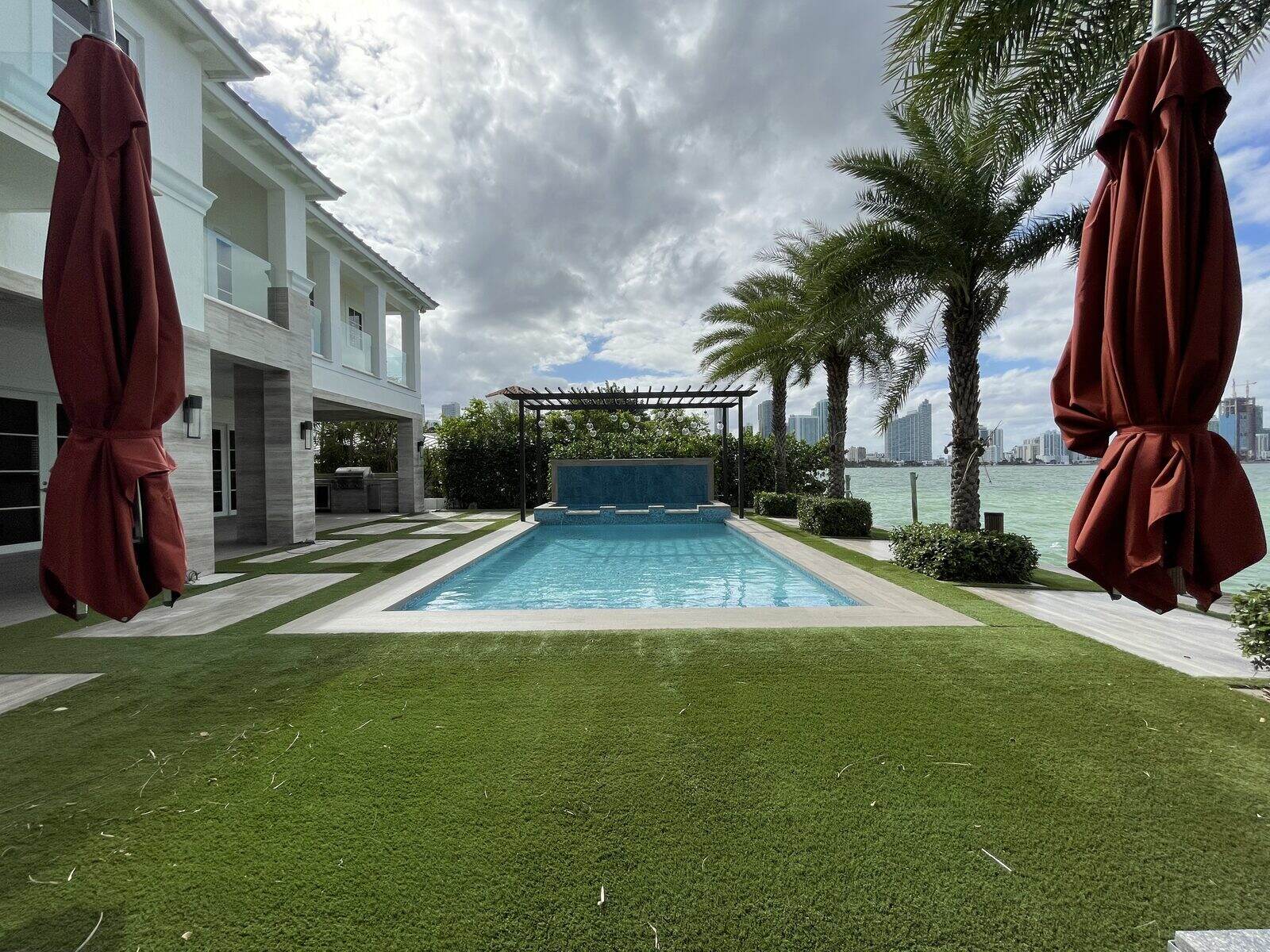 The pool and terrace of a waterfront residence looking across the bay