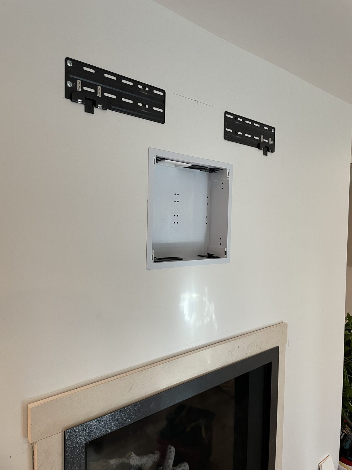The in-wall box and mount set above the fireplace before the display goes on